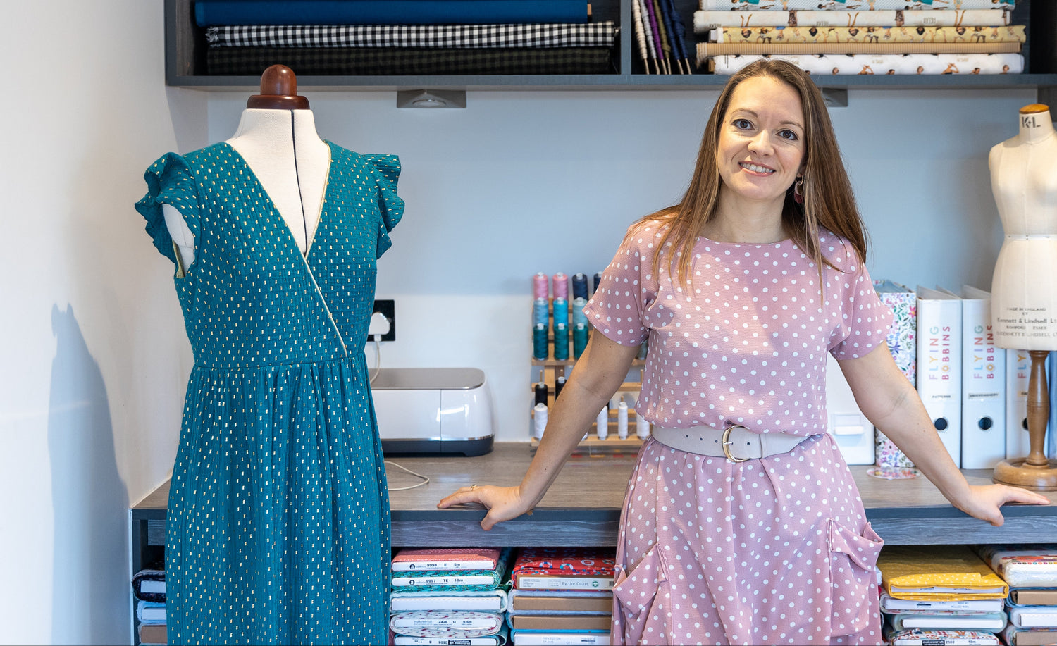 Woman standing in a room with fabric shelves and mannequins